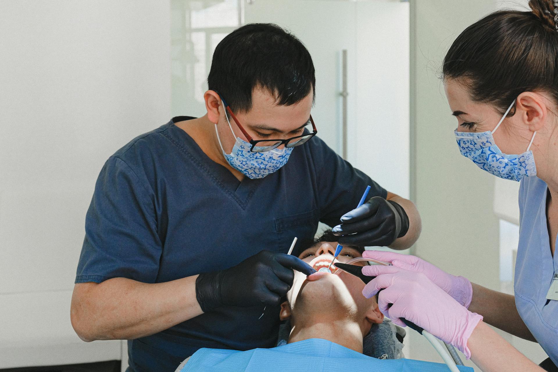 Dental professional performing a preventive teeth cleaning in the treatment chair